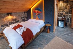 a bedroom with a large bed in a stone wall at Hobbit Chalet in Çamlıhemşin
