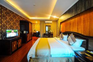 a bedroom with a large bed and a television at Interpark Hotel in Olongapo