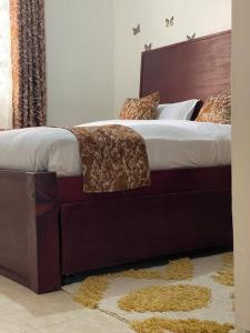 a bedroom with a large bed with a wooden headboard at Dzefry Homes in Nakuru