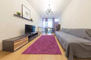 a bedroom with a large bed and a pink rug at Urbannestgroup - City Center - Pereca 2 in Warsaw