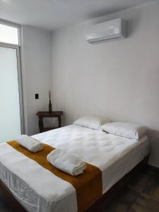 um quarto branco com 2 camas e uma janela em Villas Carlota Cancún em Cancún