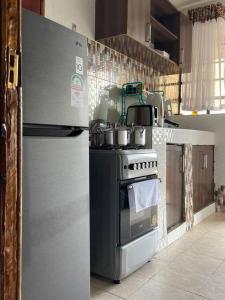 a kitchen with a refrigerator and a stove at Dzefry Homes in Nakuru