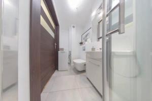 a bathroom with a toilet and a wooden door at Urbannestgroup - City Center - Pereca 2 in Warsaw