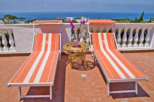 two benches sitting on a balcony with a table at Aparthotel Villa Marinù in Ischia