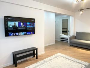 ein Wohnzimmer mit einem Sofa und einem TV an der Wand in der Unterkunft Apartment Dzerzhinskogo in Öskemen