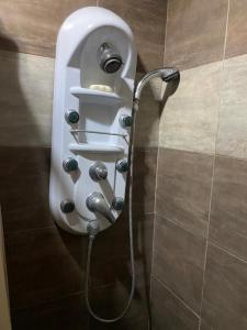 einem Wasserschlauch, der mit einem Urinal in einem Bad verbunden ist in der Unterkunft Suite Bosque de la Alborada B in Guayaquil