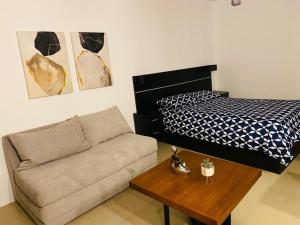 Suite Bosque de la Alborada B في غواياكيل: غرفة معيشة مع أريكة وسرير