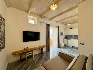 a living room with a couch and a tv on a wall at YourHome - Nettuno Apartments in Piano di Sorrento