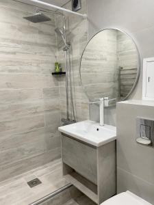 a bathroom with a sink and a mirror at Apartment Dzerzhinskogo in Ustʼ-Kamenogorsk