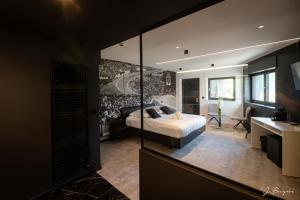 een slaapkamer met een bed en een bureau in een kamer bij Les Thermes de Spa by La Cour de la Reine Hôtel, Suites & accès gratuit au centre thermal in Spa