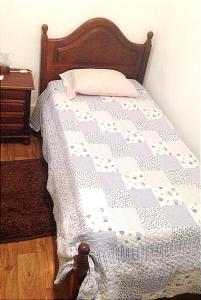 a bed with a blue and white quilt on it at Residencial clérigos ROOM 3 in Porto