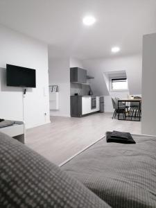 赫內的住宿－estrella24 LIVING ROOMS Chita，白色的客房设有床、厨房和桌子