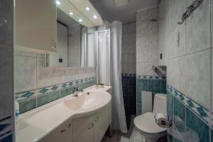 a bathroom with a sink and a toilet and a mirror at Romeo Family Apartments in Tallinn +71 photos