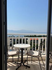 uma mesa e cadeiras numa varanda com vista para o oceano em Apartments Mateljak em Gradac