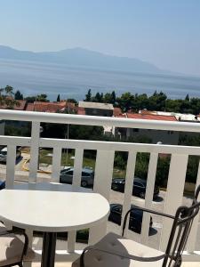 una mesa y sillas en un balcón con vistas a un aparcamiento en Apartments Mateljak, en Gradac