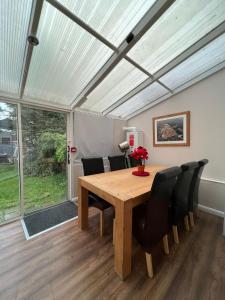 une salle à manger avec une table en bois et des chaises noires dans l'établissement 4 Bedroom holiday home, à Woodford