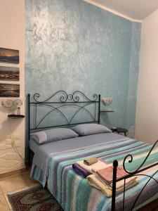 sypialnia z łóżkiem z niebieską ścianą w obiekcie BLUE SEA w mieście Roccella Ionica