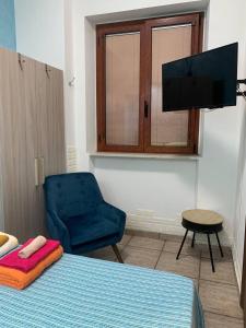 sypialnia z łóżkiem, krzesłem i telewizorem w obiekcie BLUE SEA w mieście Roccella Ionica