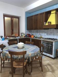 kuchnia ze stołem, krzesłami i kuchenką w obiekcie BLUE SEA w mieście Roccella Ionica