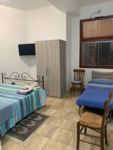 sypialnia z 2 łóżkami, stołem i krzesłem w obiekcie BLUE SEA w mieście Roccella Ionica
