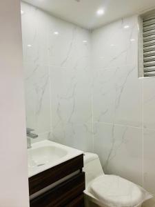 a white bathroom with a sink and a toilet at Alquiler Apartamento en Bogotá cerca al aeropuerto-Colibri Dorado in Bogotá