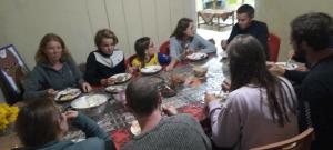 un grupo de personas sentadas alrededor de una mesa comiendo comida en Karleta Homestay, en Ruteng