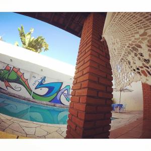 a brick pillar in front of a wall with graffiti at Black Hotel in Bauru