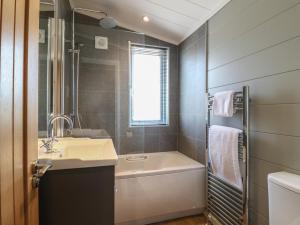 特倫托河上的紐瓦克的住宿－Holly Lodge，浴室配有盥洗盆和浴缸。