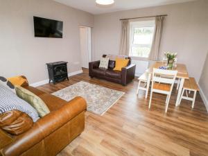 ein Wohnzimmer mit einem Sofa und einem Tisch in der Unterkunft Rose Cottage in Omagh