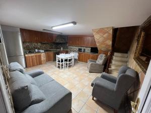 sala de estar con sofá y sillas y cocina en La Casa de la Abuela, en Pobra do Caramiñal