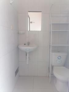 Baño blanco con lavabo y aseo en Chimicuas House, en Puerto Maldonado