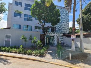 a building with a tree in front of it at Fuja para o Paraíso em Porto de Galinhas! in Porto De Galinhas