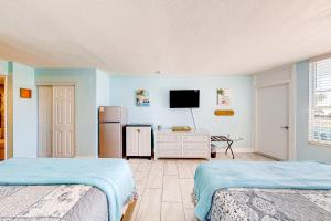 a large room with two beds and a refrigerator at Right Along the Beach in Daytona Beach