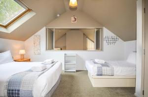 a attic bedroom with two beds and a mirror at A Hop, Skip & Jump to The Lake in Taupo