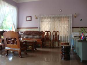 a living room with wooden furniture and a window at Sam So Guesthouse in Siem Reap
