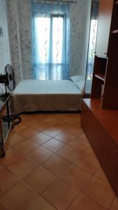 ein Schlafzimmer mit einem Bett, einem Fenster und einem gefliesten Boden in der Unterkunft WINTAGE in Marino