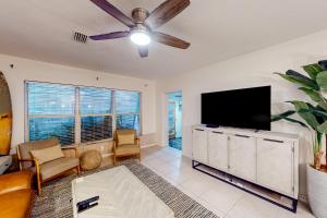 salon z telewizorem z płaskim ekranem i kanapą w obiekcie Turquoise Breezes A w mieście Cocoa Beach