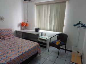 - une chambre avec un lit, un lavabo et une chaise dans l'établissement Apartamento Compartilhado, com 02 Quartos, sendo 01 suíte, à Manaus