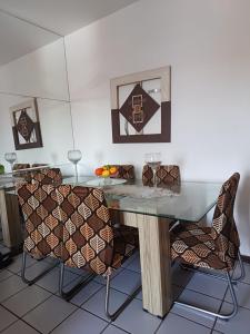 uma sala de jantar com uma mesa de vidro e 2 cadeiras em Apartamento Compartilhado, com 02 Quartos, sendo 01 suíte em Manaus