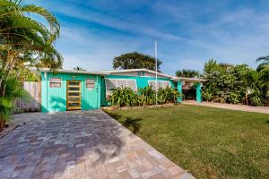 una casa blu con un prato davanti di Turquoise Breezes A a Cocoa Beach