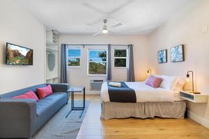 um quarto com uma cama e um sofá em Bloom Hideaway - Mins to Las Olas & Beach em Fort Lauderdale