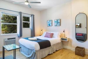 um quarto com uma cama grande e um espelho em Bloom Hideaway - Mins to Las Olas & Beach em Fort Lauderdale
