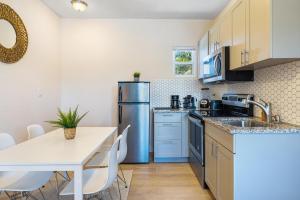 a kitchen with a table and a refrigerator at Bloom Hideaway - Mins to Las Olas & Beach in Fort Lauderdale
