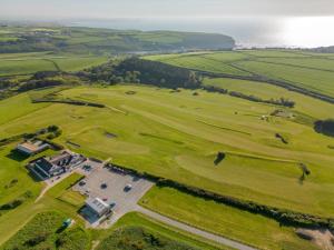an aerial view of a golf course with the ocean in the background at Cosy room with golf & the beach on your doorstep! in Mawgan Porth
