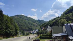 een straat in een dorp met bergen op de achtergrond bij Ski lift apartman dm Brzeće in Brzeće