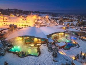 een resort dat 's nachts bedekt is met sneeuw bij ROYAL HILL II in Białka Tatrzanska