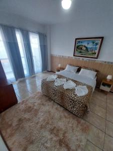 a bedroom with a leopard print bed and a rug at Pousada toca do cambu in Angra dos Reis