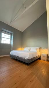 uma cama grande num quarto com piso em madeira em Matriz 55, Hostel & Suites em Ponta Delgada