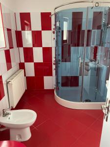 a red and white bathroom with a shower and a toilet at Oficial Haus in Cristian