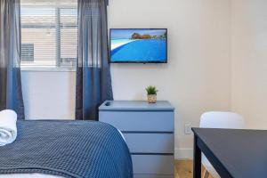 フォート・ローダーデールにあるAzure - Mins to Las Olas & Beachのベッドルーム1室(ベッド1台、壁掛けテレビ付)